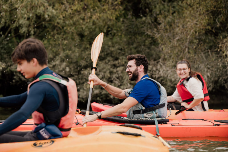 Trois amis réalisant du canoë-kayak