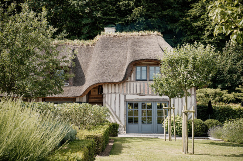 Ferme chaumière normande blanche et bois avec jardin