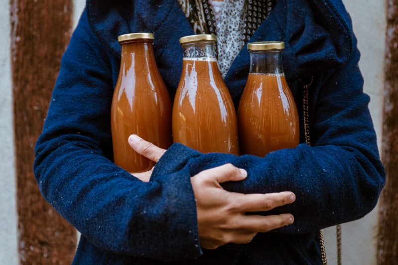 Personne tenant trois bouteilles de cidre