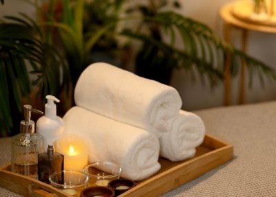 Serviettes de bain, huiles essentielles et bougie pour un moment de détente