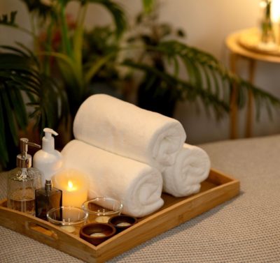 Serviettes de bain, huiles essentielles et bougie pour un moment de détente