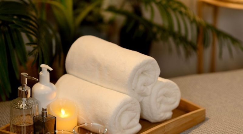 Serviettes de bain, huiles essentielles et bougie pour un moment de détente